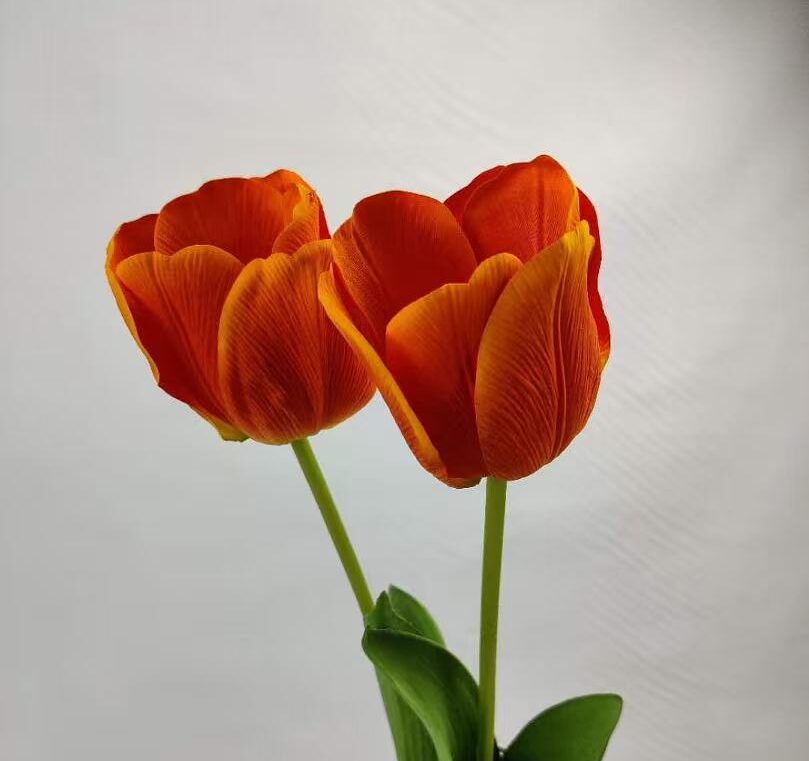 two artificial real touch orange tulips